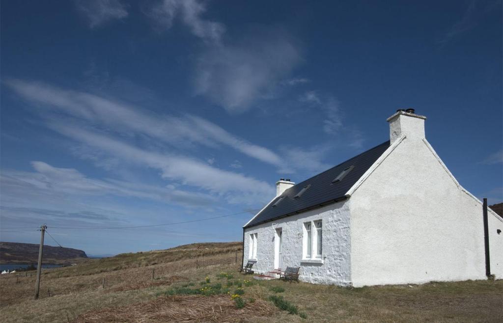 a small white building on a hill with a blue sky at 21 Upper Edinbane in Edinbane