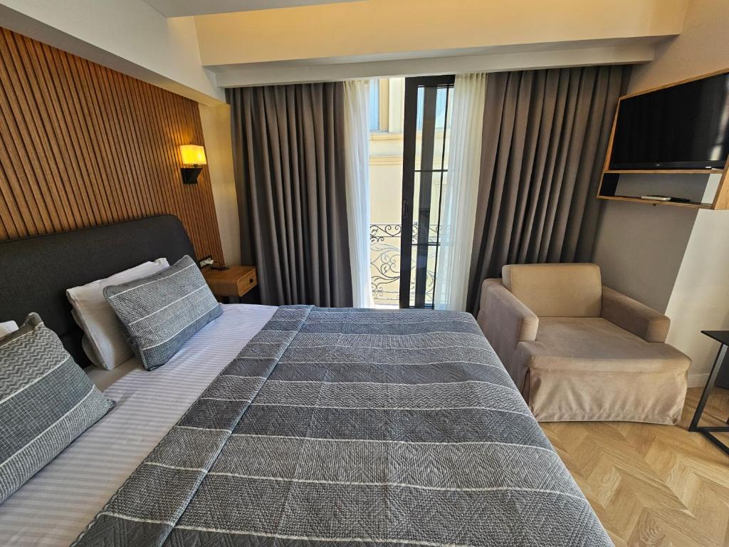 a hotel room with a large bed and a chair at Anthemis Hotel in Istanbul