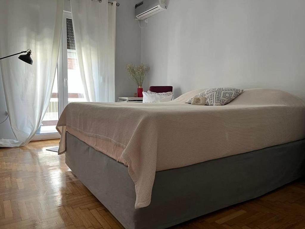 um quarto com uma cama grande e uma colcha branca em Athenian Zen em Atenas