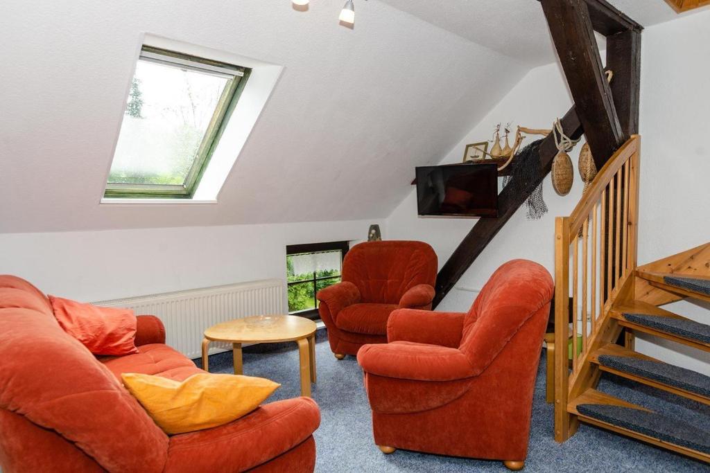 a living room with two chairs and a staircase at 3-Raum-FeWo-fuer-4-Personen-in-Schaprode-auf-Ruegen-Zi5 in Schaprode