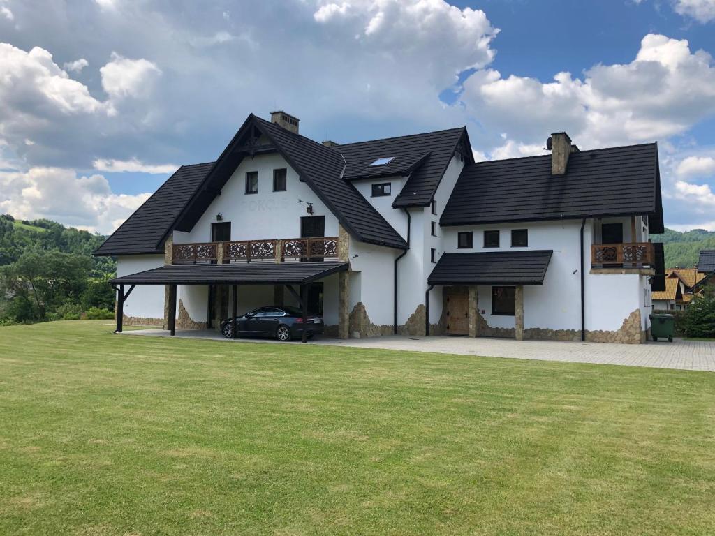 a large white house with a black roof at SOBEL II in Tylmanowa