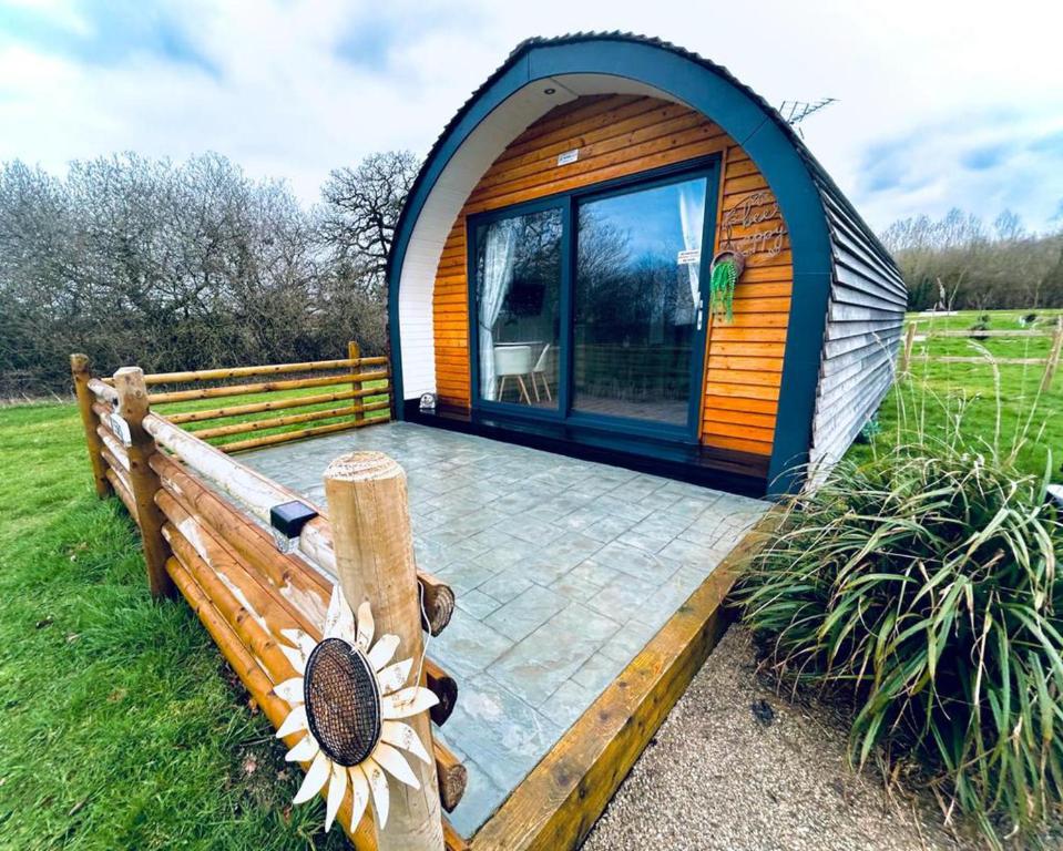 a tiny house with a large window and a deck at Luxury Pod Cabin in beautiful surroundings Wrexham in Wrexham