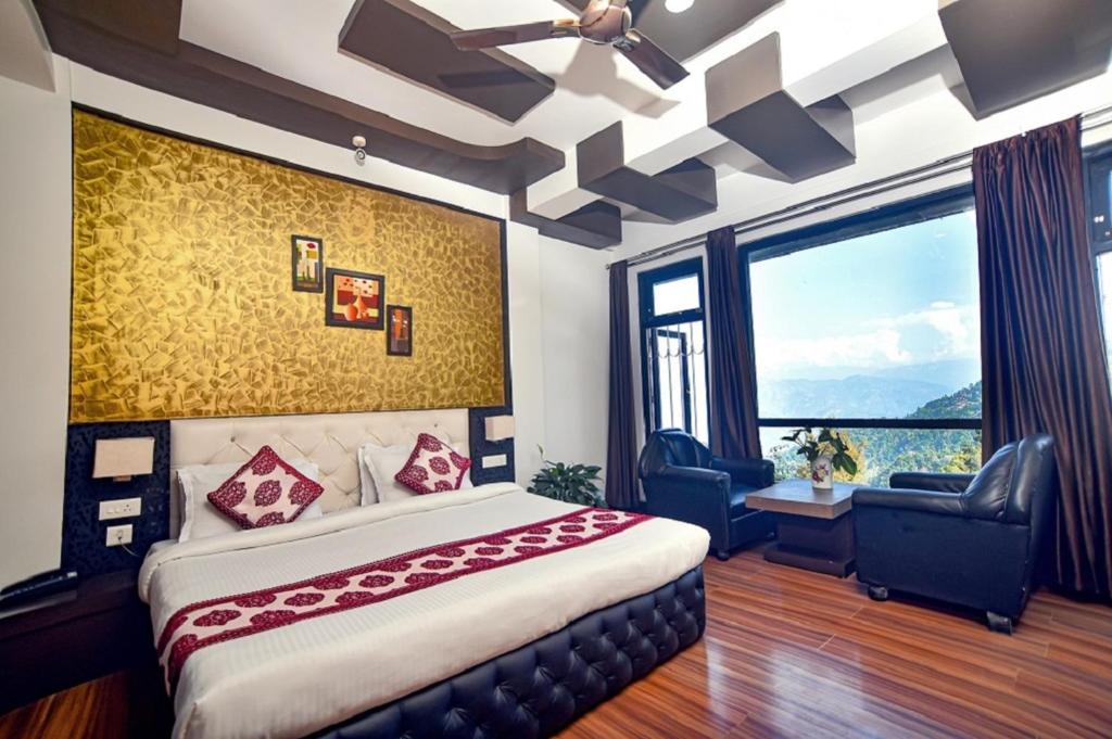 ein Schlafzimmer mit einem großen Bett und einem großen Fenster in der Unterkunft Sood's Himalayan Vista in Kalimpong