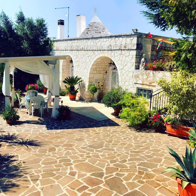 un patio de piedra con mesa y dosel blanco en Il Trullo di Nonno Angelo San Marco, en Locorotondo