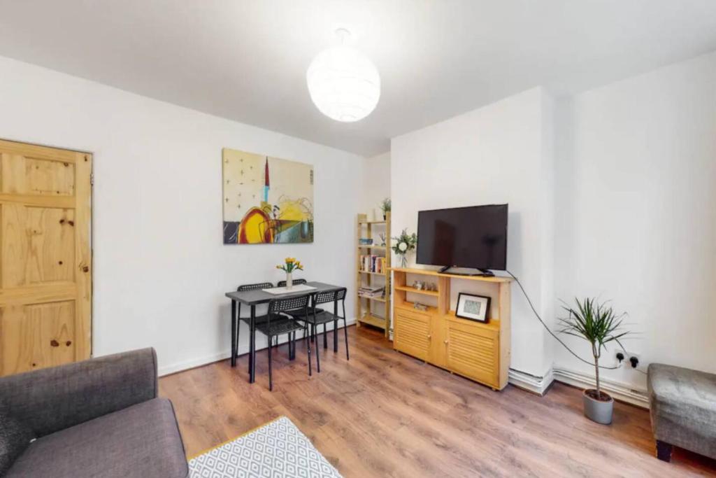 a living room with a table and a television at Central & Cosy 2BD Flat near Canary Wharf in London
