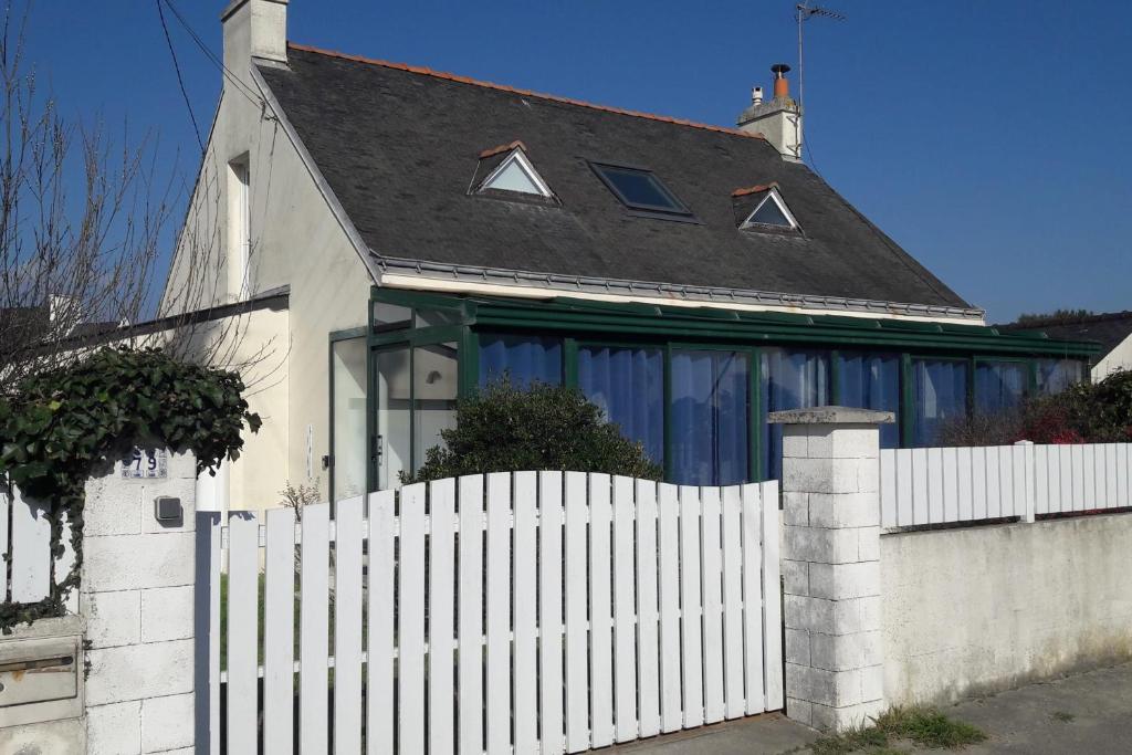 biały płot przed białym domem w obiekcie Maison proche centre ville et plage w mieście Quiberon