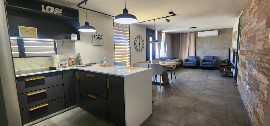 a kitchen with black cabinets and a living room at Villamar in Fajardo