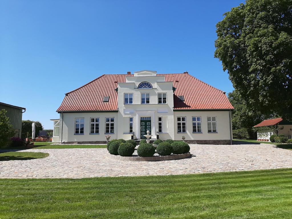 a large white house with a red roof at Gutshaus Neu Farpen in Neuburg