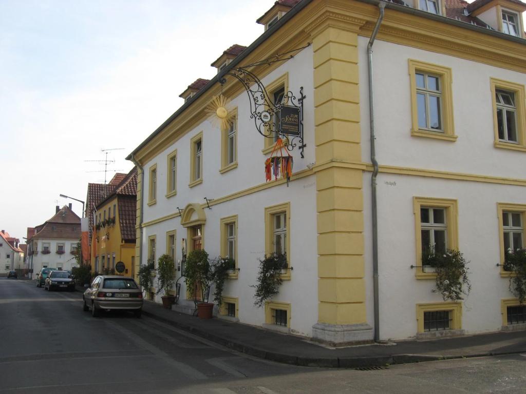 a yellow and white building on the side of a street at Gasthaus zur Sonne in Nordheim