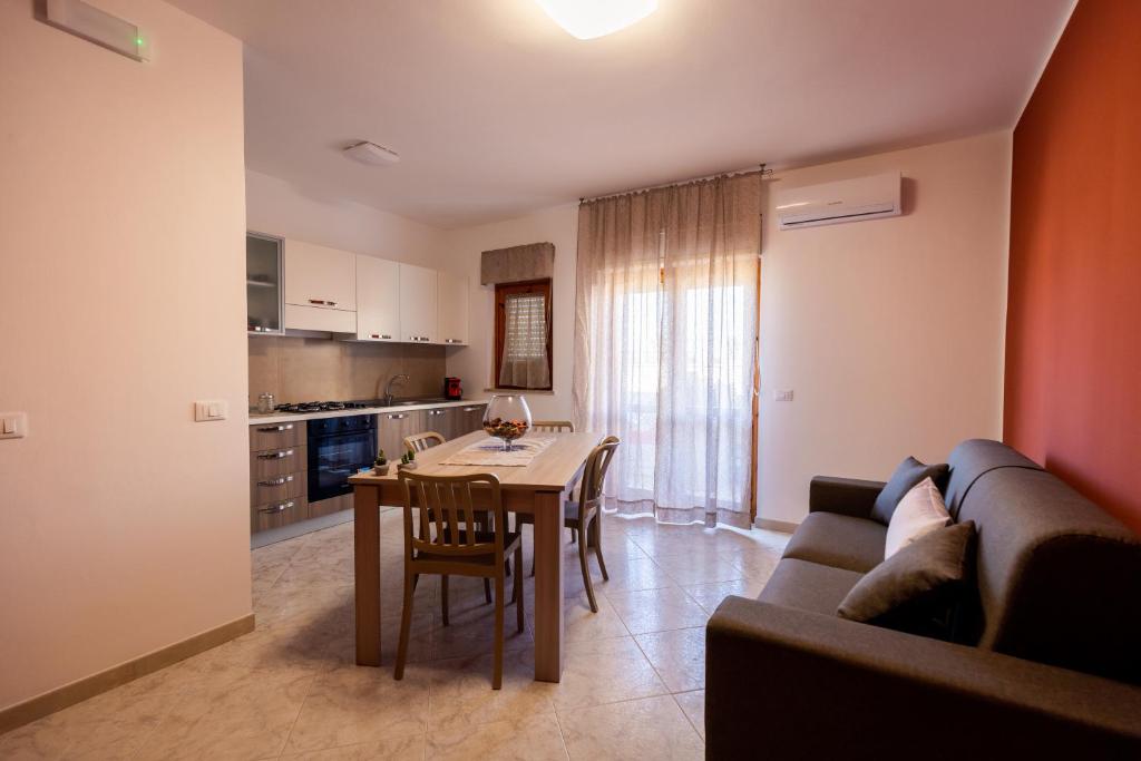a kitchen and dining room with a table and a couch at Sole & Luna Apartment in Marsala