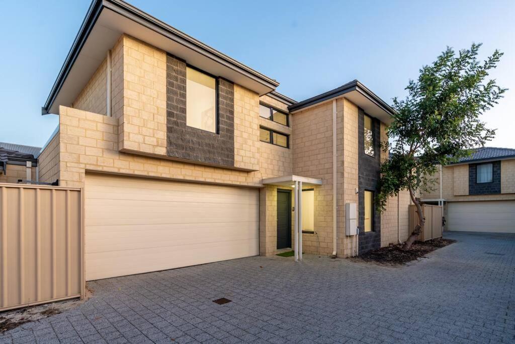 a brick house with a garage at Modern Family Escapes Shopping at your doorstep in Perth