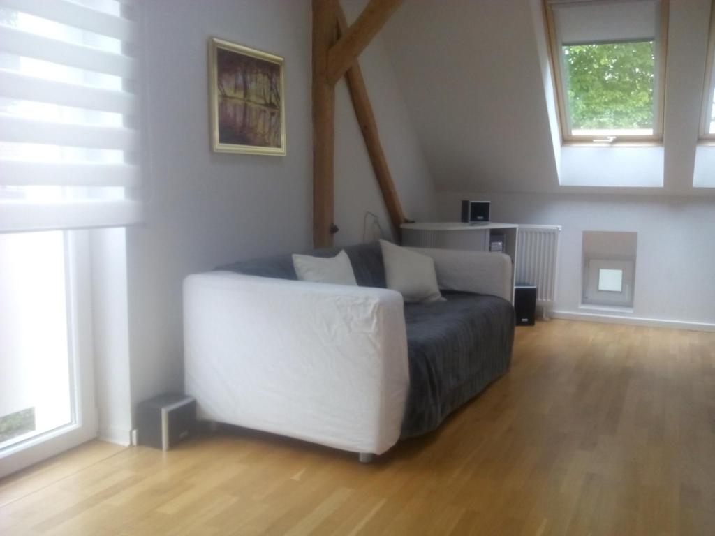 a living room with a white couch and two windows at Ferienwohnung am Teupitzsee in Teupitz