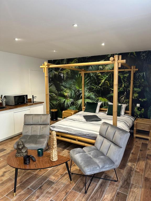 a bedroom with a bed and two chairs at Jungle room in Sotteville-lès-Rouen