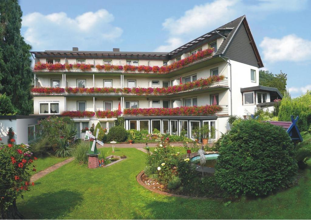 a large white building with flowers in the yard at Hotel Aura am Schloss in Bad Pyrmont