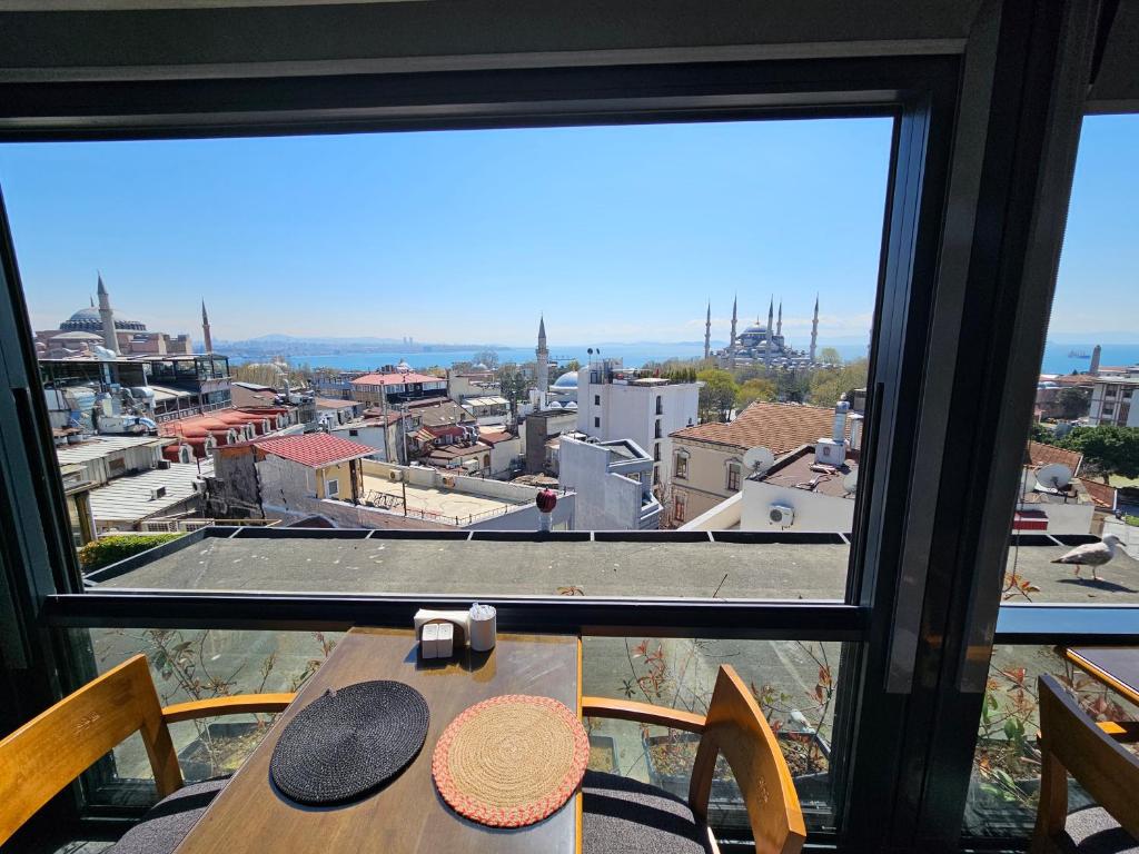 a table with a view of a city from a window at Anthemis Hotel in Istanbul