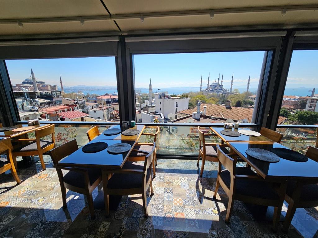 a dining room with tables and views of the city at Anthemis Hotel in Istanbul