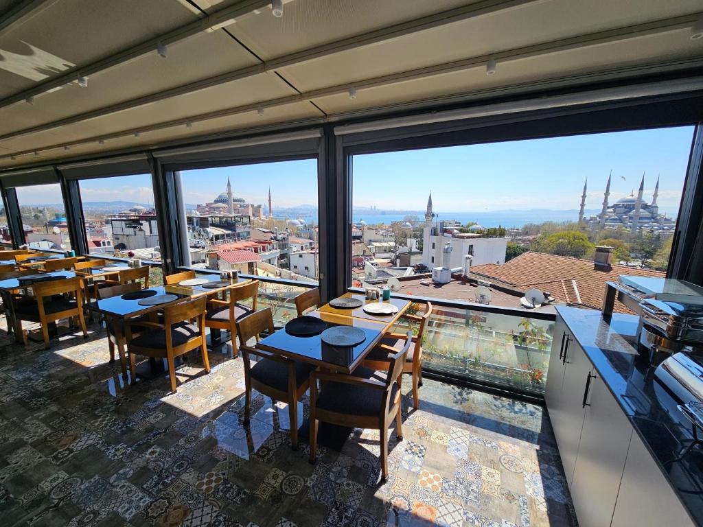 a restaurant with tables and chairs and large windows at Anthemis Hotel in Istanbul