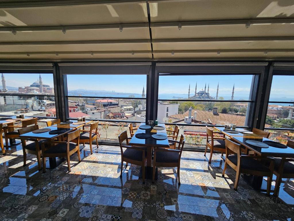 a restaurant with tables and chairs in a room with windows at Anthemis Hotel in Istanbul