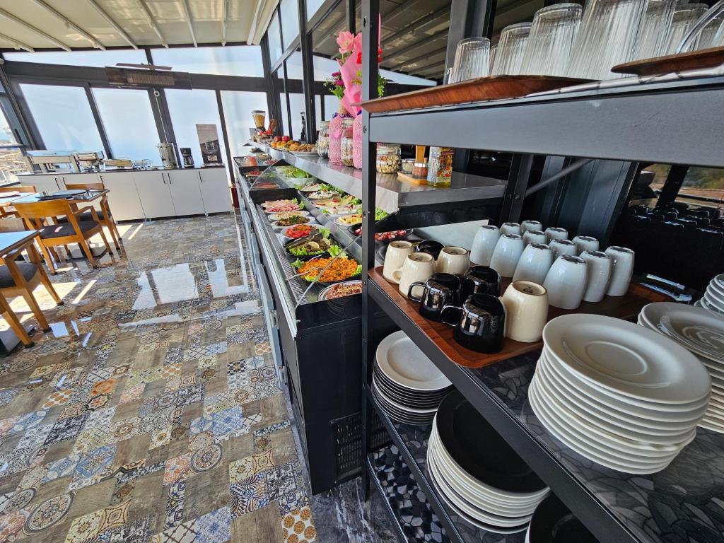a buffet line with plates and dishes in a restaurant at Anthemis Hotel in Istanbul