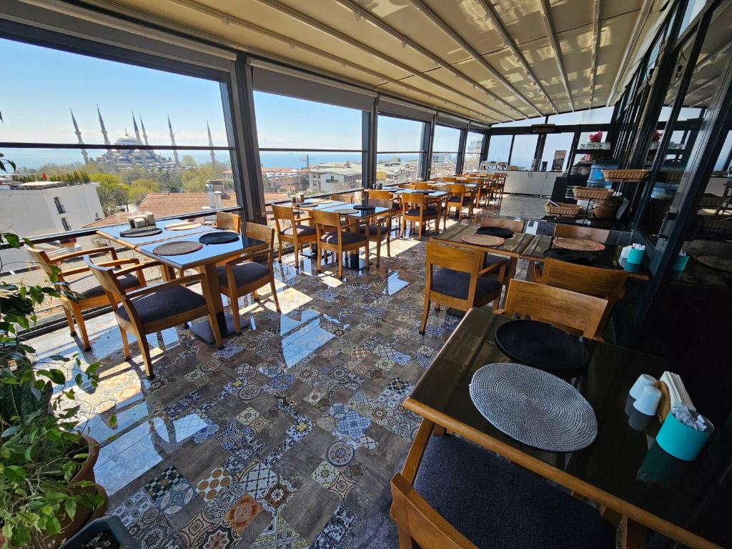 a restaurant with tables and chairs and windows at Anthemis Hotel in Istanbul