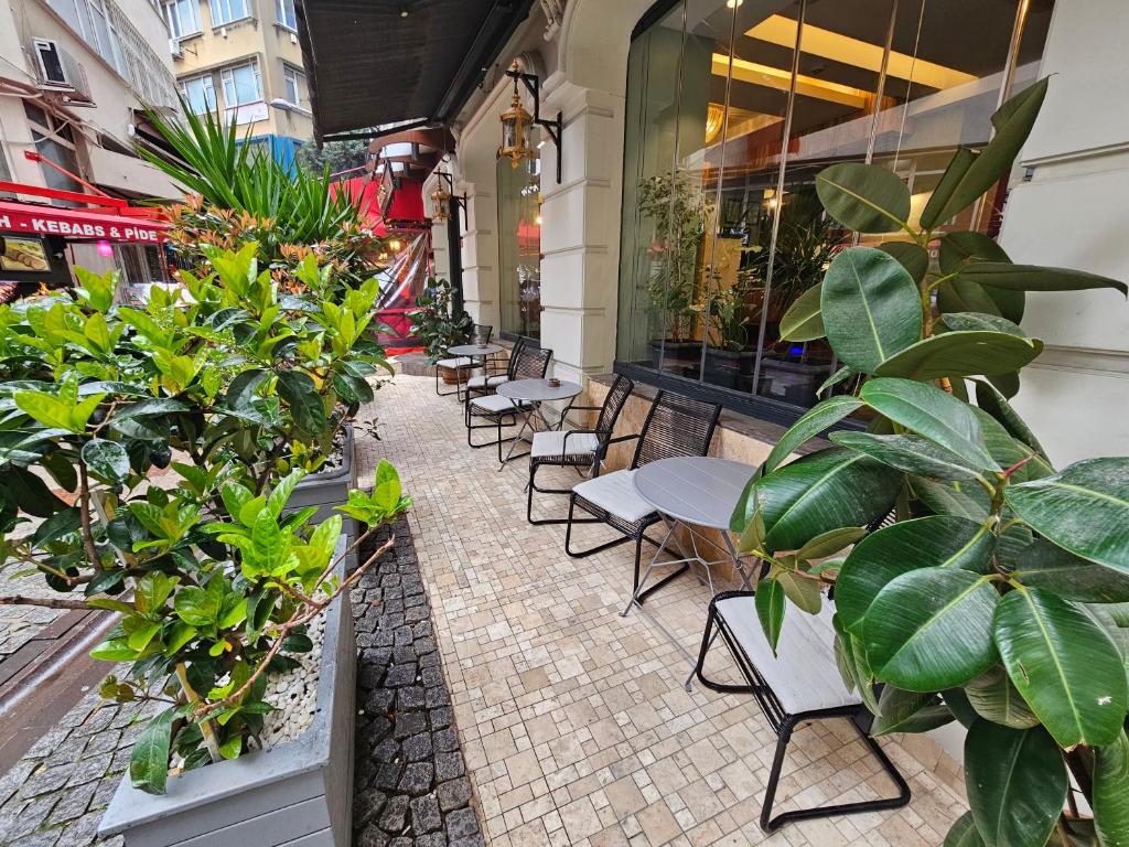 a patio with tables and chairs and potted plants at Anthemis Hotel in Istanbul