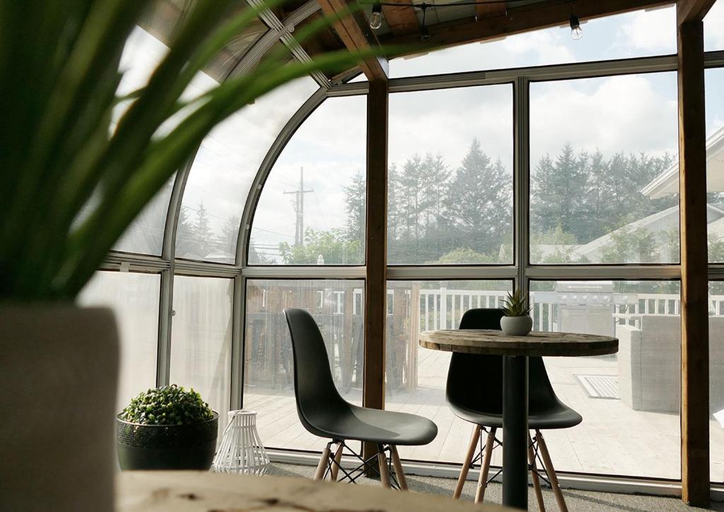 a room with a table and chairs in front of a window at Auberge Le Chic in Maniwaki