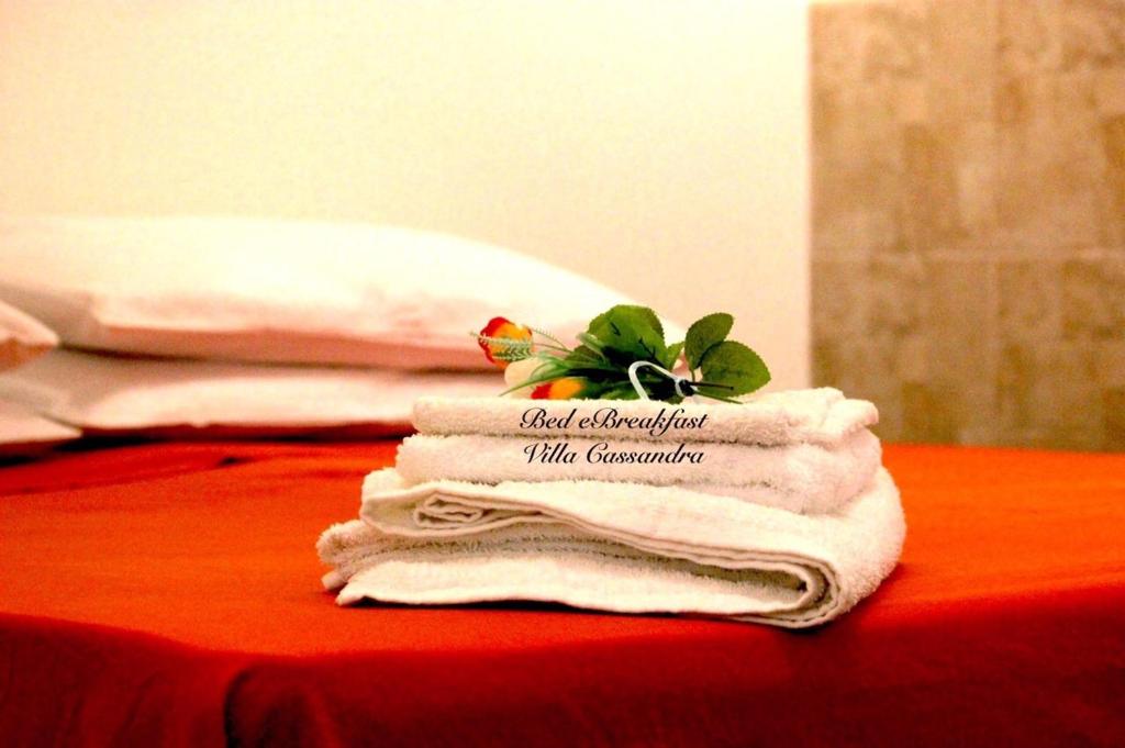 a stack of towels with a plant on top at B&B Villa Cassandra in Castellana Grotte