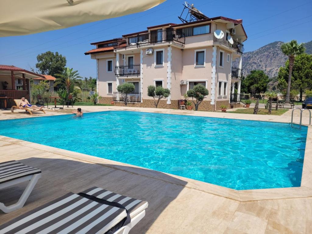 a villa with a swimming pool in front of a house at Oasis Apart Hotel in Dalyan