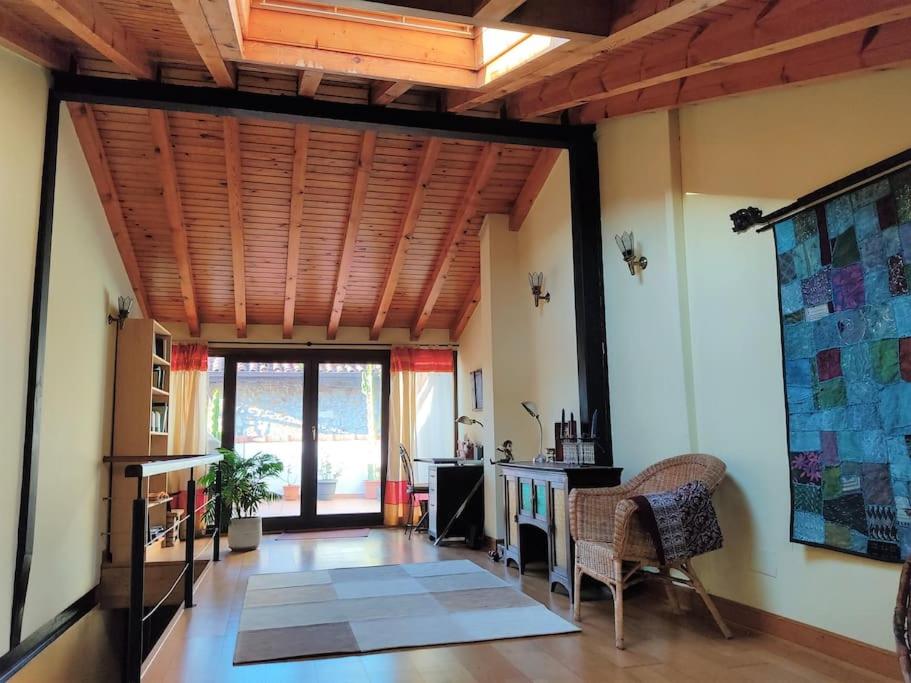 ein Wohnzimmer mit einer Holzdecke und einem Schreibtisch in der Unterkunft Casa Maitri- con piraguas junto a la ría in Limpias