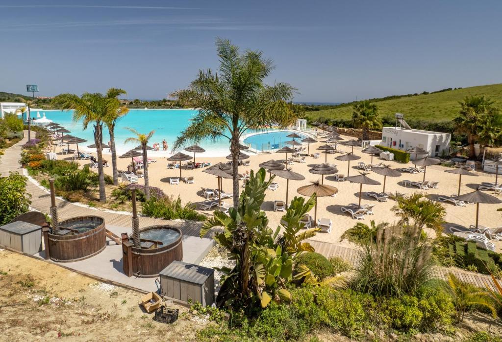una vista aérea de una playa con sombrillas y una piscina en 2214-Modern apt with private beach, en Estepona