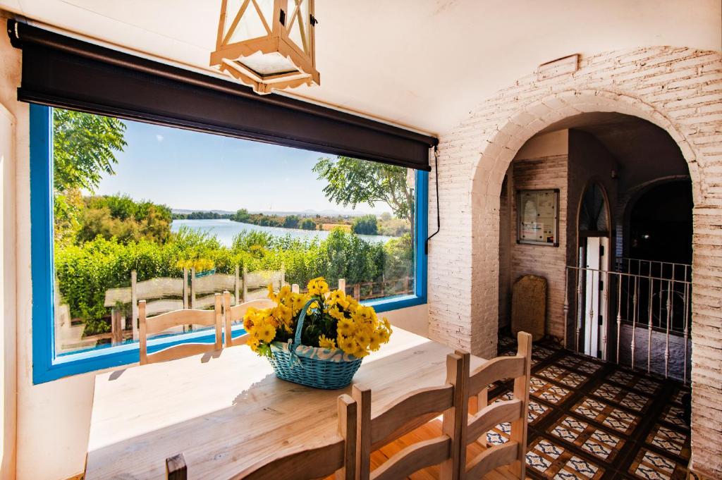 comedor con mesa y ventana grande en Casa Rural La Pontezuela, en El Puente del Arzobispo