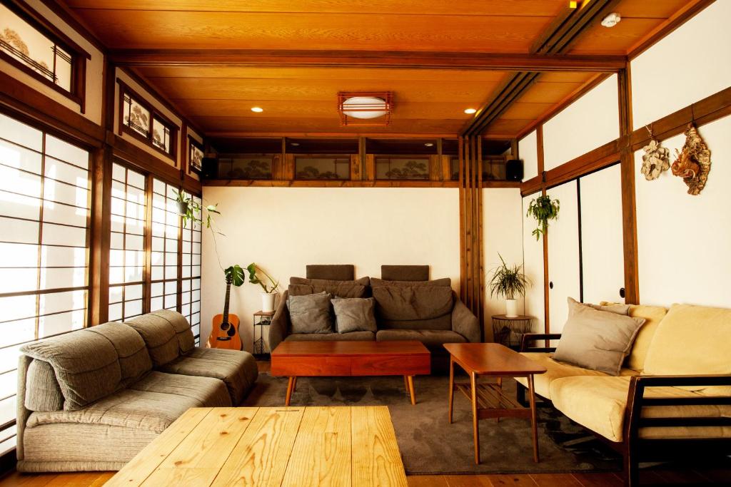 sala de estar con sofá y mesa en 長瀞NEMAKI, en Nogami