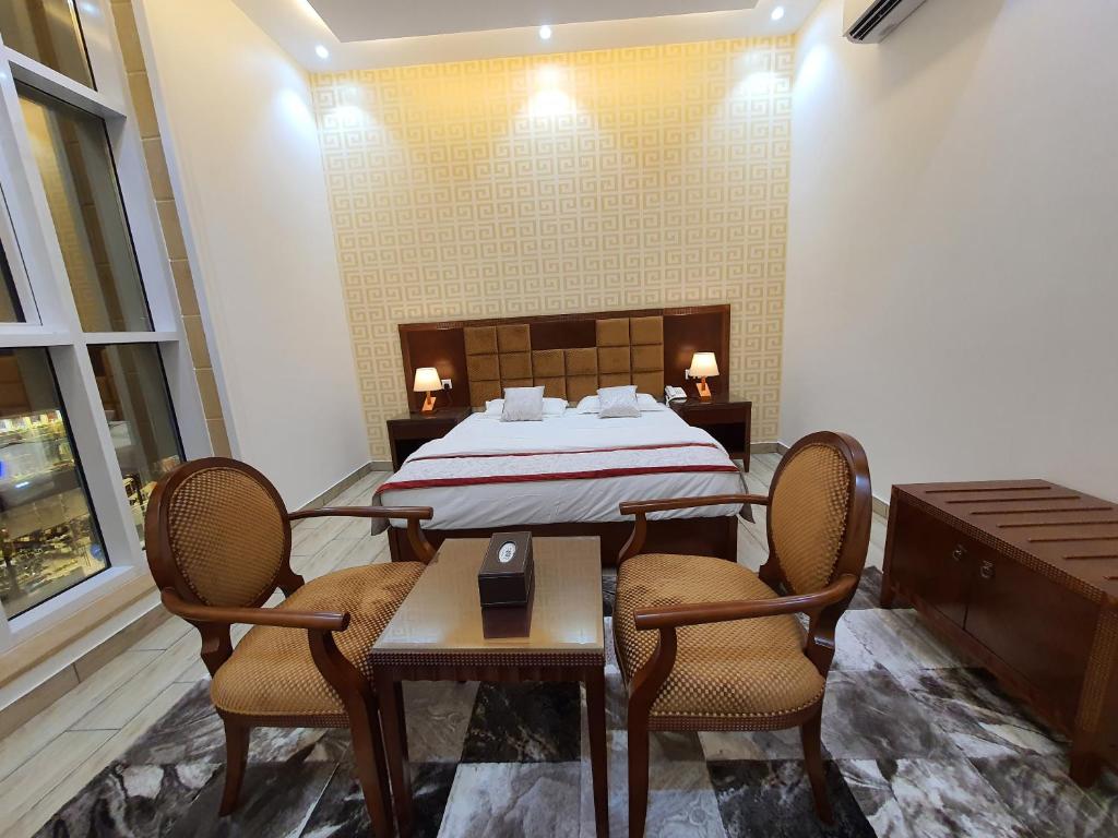 a room with a bed and two chairs and a table at فندق درة الرؤية in Jeddah