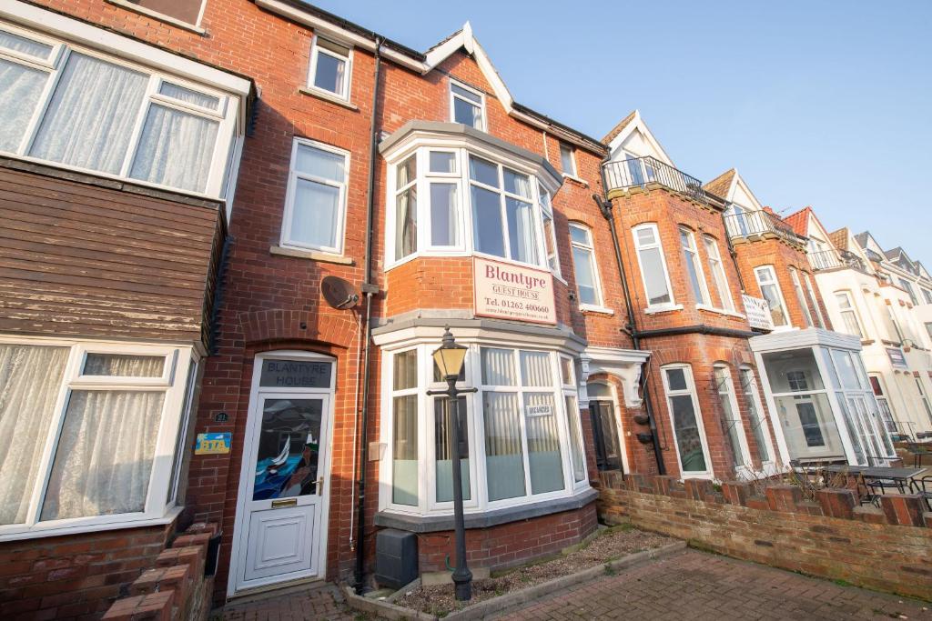 a row of brick houses on a street at Blantyre Guest House in Bridlington