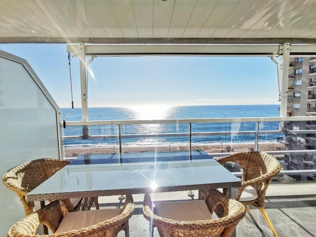 a table on a balcony with a view of the ocean at Seafront apartment in Blanes in Blanes