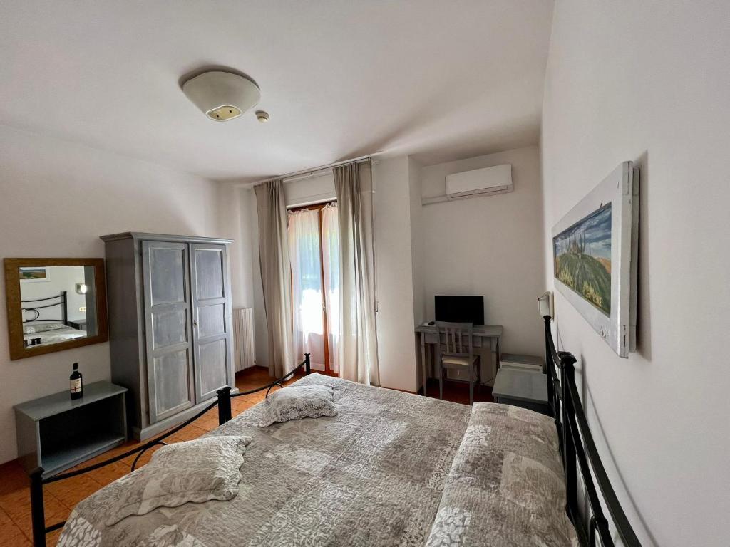 um quarto com uma cama grande e uma janela em Hotel Marvin em Montepulciano