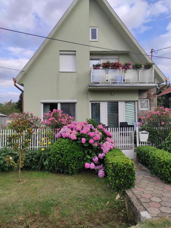 a house with pink flowers in front of it at Magdaléna Holiday Home in Zalakaros