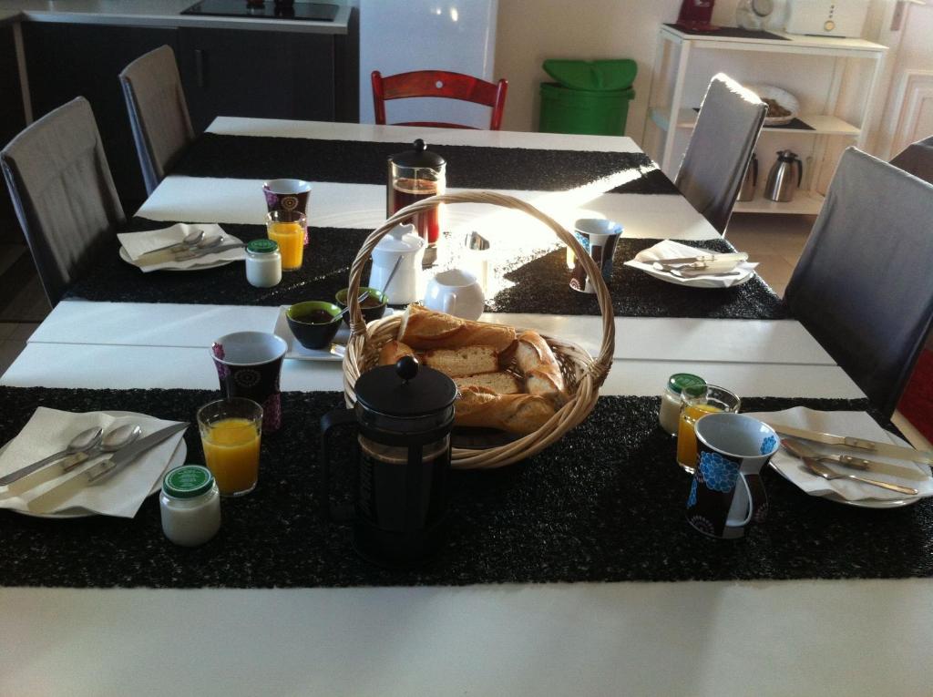 a table with a basket of food and orange juice at La Vigneraie de Meusnes in Meusnes
