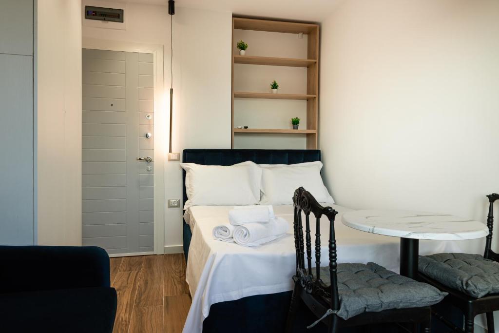 - une chambre avec un lit, une table et des chaises dans l'établissement Cozy and Chic Studio Apartment, à Tirana