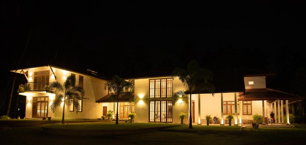 un gran edificio blanco por la noche con luces en Tectona Grandis - Negombo, en Gampaha