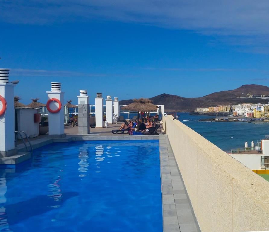 een zwembad met uitzicht op het water bij Hotel Concorde in Las Palmas de Gran Canaria