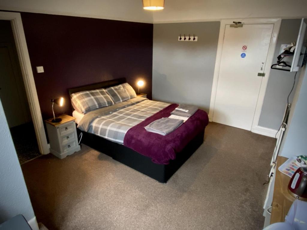 um quarto com uma cama grande e uma colcha roxa em The wrey arms inn em Barnstaple