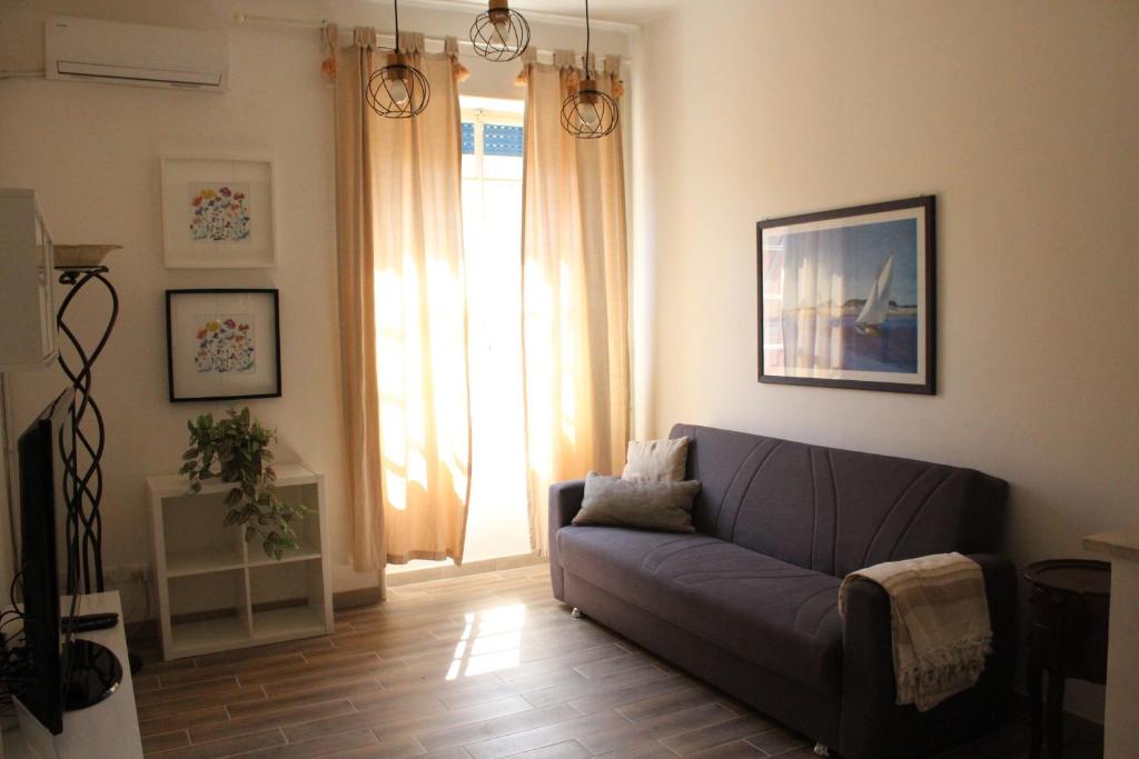 sala de estar con sofá azul y ventana en Apartment Flaminio, en Roma