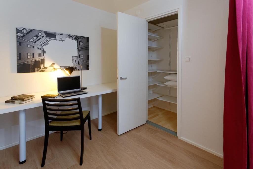 a room with a desk with a computer and a chair at Forenom Serviced Apartments Helsinki Kruununhaka in Helsinki