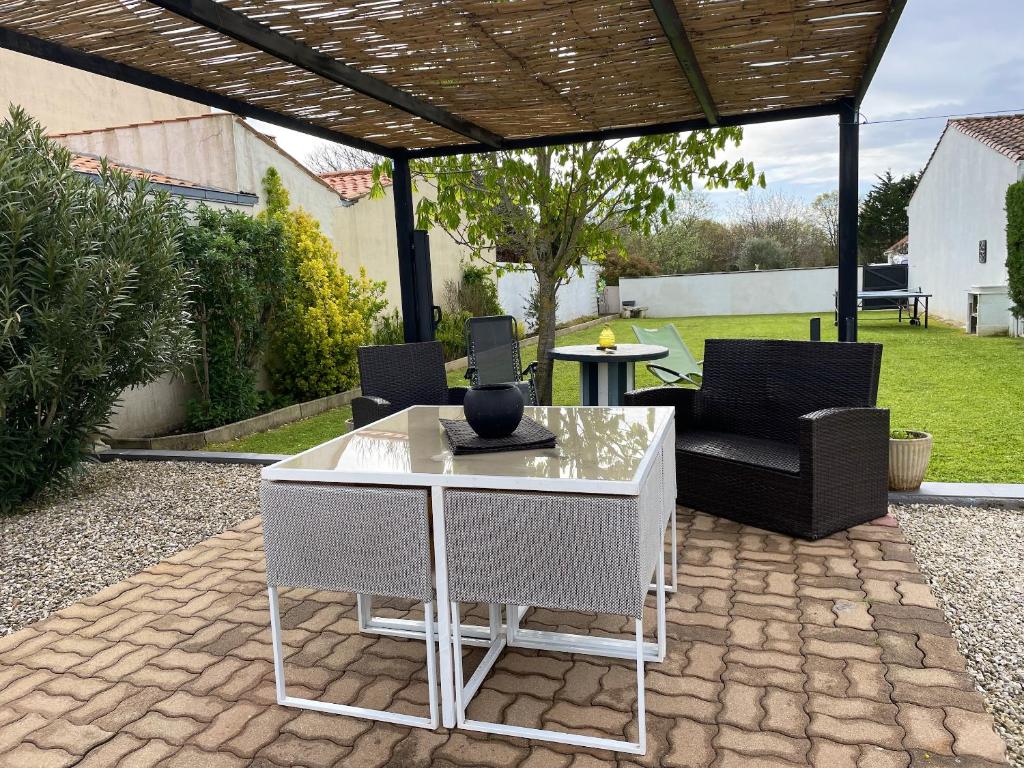 a patio with a white table and chairs in a yard at Maison de 2 chambres avec jardin clos et wifi a Saint Pierre d'Oleron a 1 km de la plage in Saint-Pierre-dʼOléron