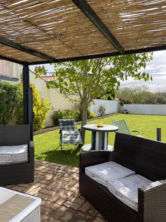 d'une terrasse avec 2 chaises, une table, une table et des chaises. dans l'établissement Maison confort & jardin à Saint-Pierre-d'Oléron, à Saint-Pierre-dʼOléron
