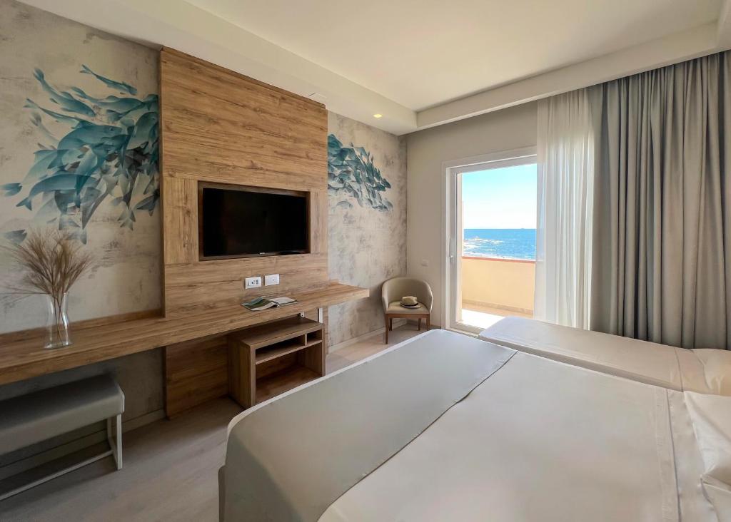 a hotel room with a large bed and a television at Hotel Rex in Livorno
