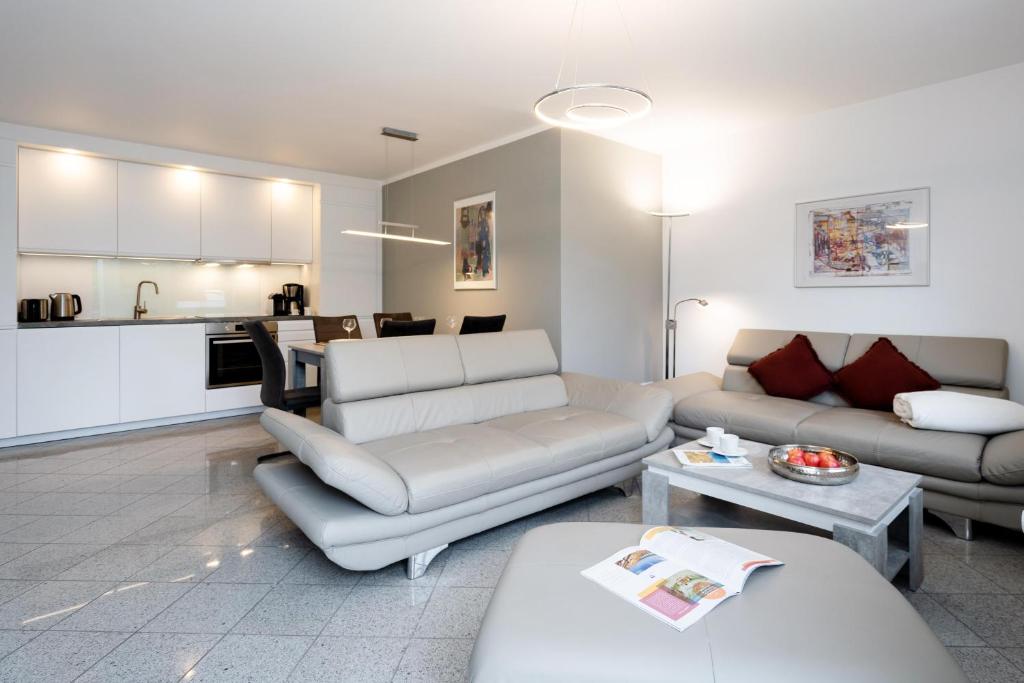 a living room with two couches and a kitchen at Albatros EG in Tinnum