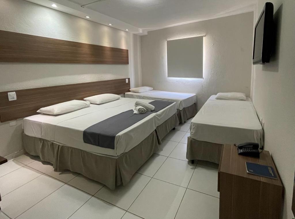 um quarto com duas camas e uma televisão em Hotel Pousada Alagoana em Maceió