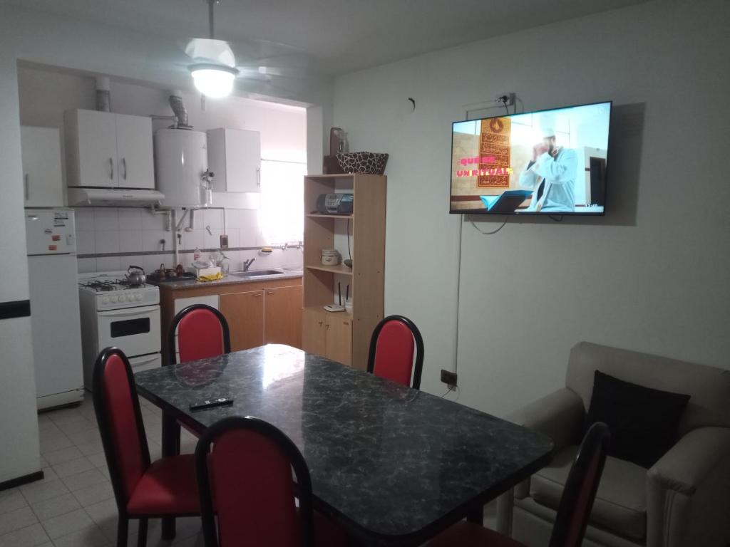 a kitchen with a table and a television on the wall at Casa Los Lapachos in La Punta